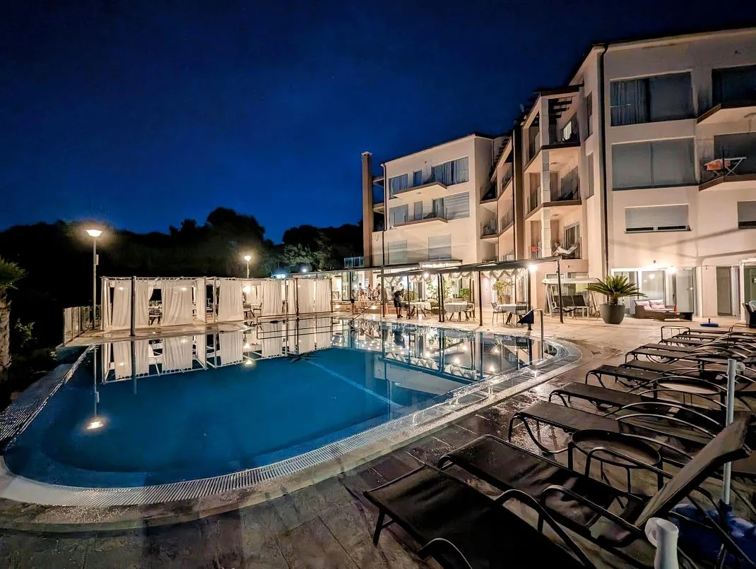 Poollandschaft und Restaurant am Abend - Hotel Premantura Resort