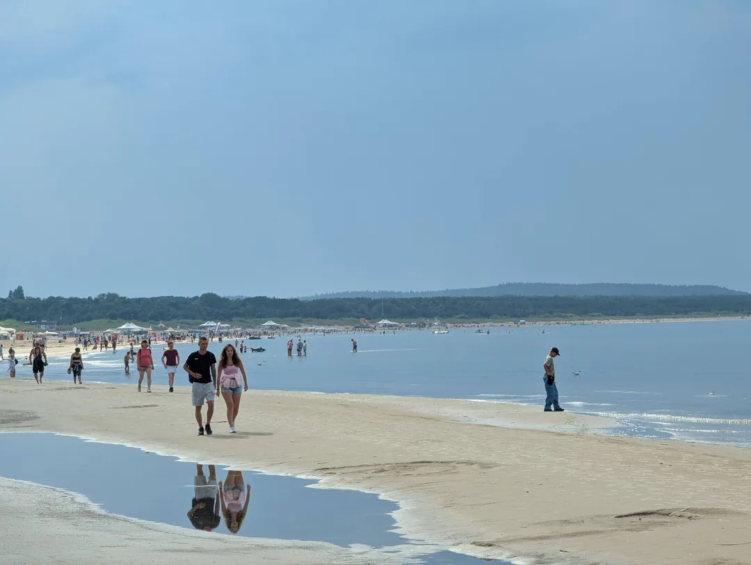 Breiter Sandstrand von Świnoujście mit Spaziergängern an einem Julitag