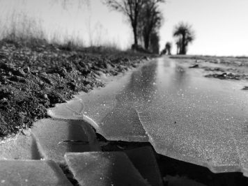 Gebrochenes Eis am Feldweg